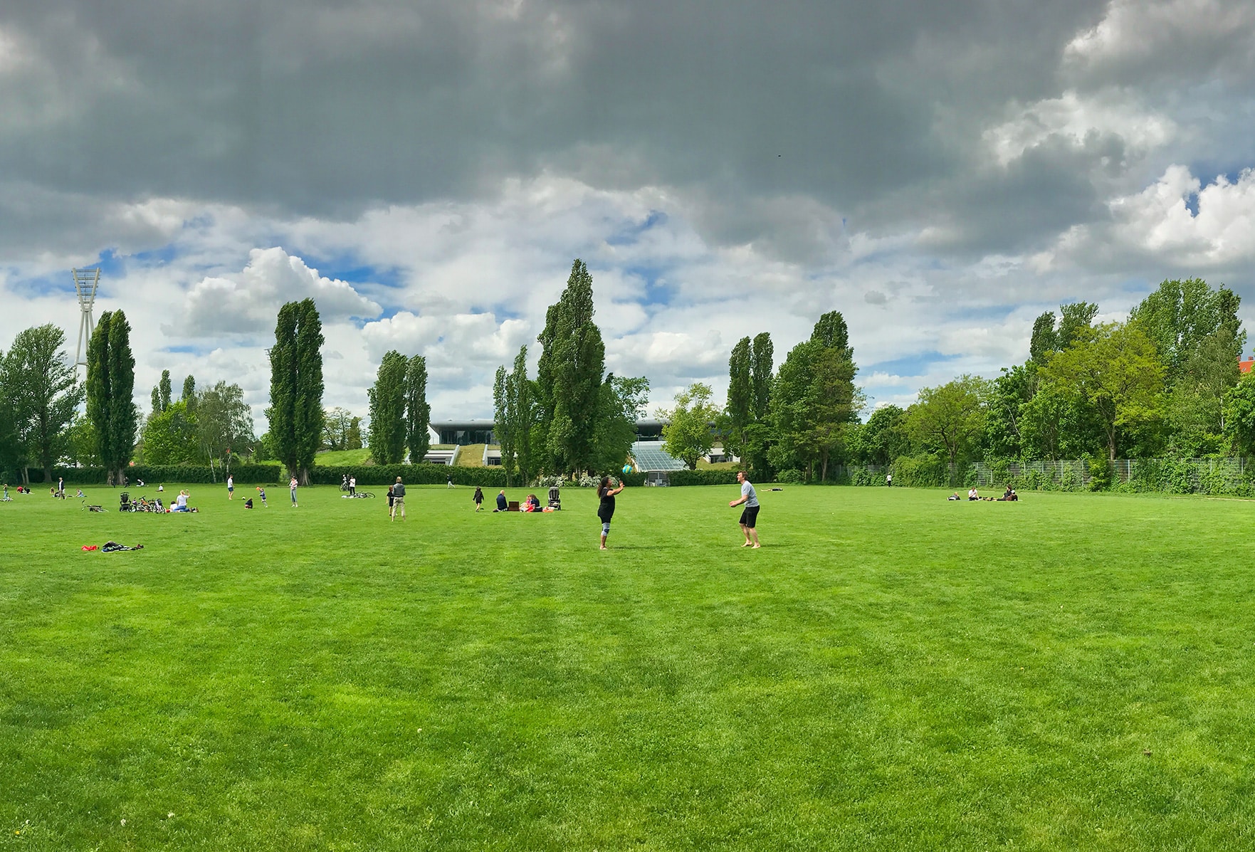 Sportwiese Jahn-Sportpark mit Menschen beim Sport und Blick auf das Stadion im Hintergrund